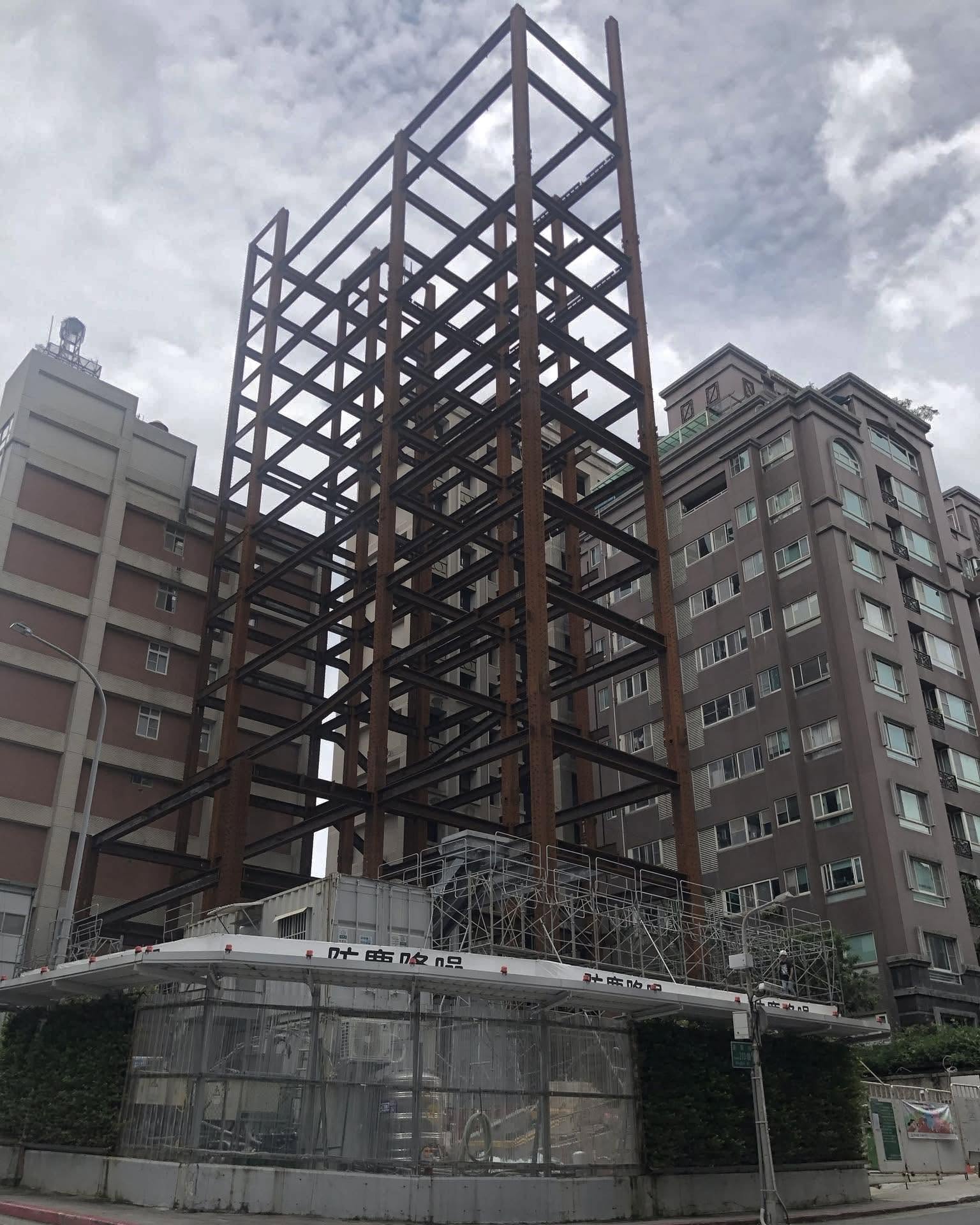 城市中豎立的鋼構骨架與施工圍籬